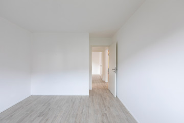 Empty room with white walls and open door on the right