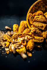 Close up of Dried dates or kharek or sukhi khajoor in a hamper with its powder on wooden surface.