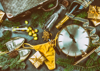 Fototapeta na wymiar LATIN AMERICAN AND SPANISH NEW YEAR TRADITIONS. empty suitcase, lentil spoon, yellow interior clothes, gold ring in champagne, 12 grapes, money in shoe. Christmas background