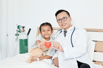 Young male doctor pediatrician checking girl