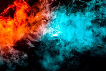 Translucent, thick smoke, illuminated by light against a dark background, divided into two colors: blue and red, burns out, evaporating from a pair of vape.