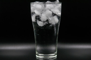 Glass of pure water with ice cubes. Isolated on black background