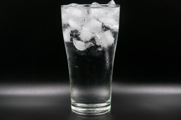 Glass of pure water with ice cubes. Isolated on black background
