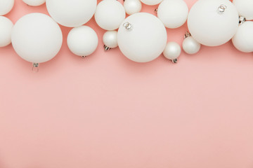 Christmas winter composition. White christmas balls on a pastel pink background