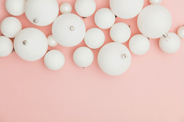 Christmas winter composition. White christmas balls on a pastel pink background