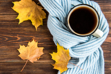 Tea cup and autumn leaves on wooden background. Flu season in autumn, disease.