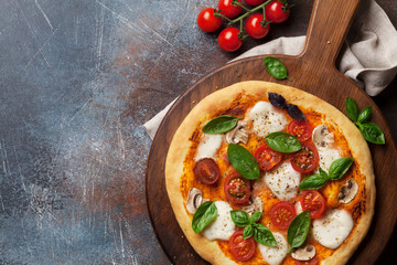 Italian pizza with tomatoes, mozzarella and basil