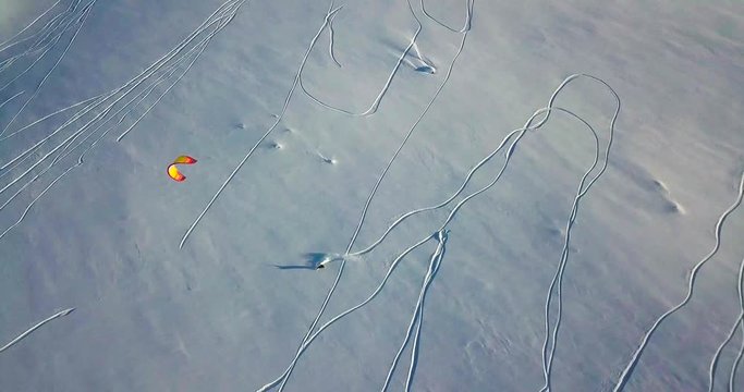 Aerial view of people snowkiting in tundra.