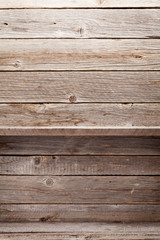 Fototapeta na wymiar Empty wooden shelves in front of wooden wall