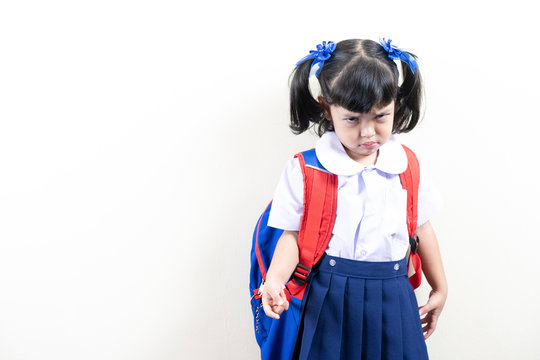 lazy kid do not want to go to school. Asian little schoolgirl with the angry face.