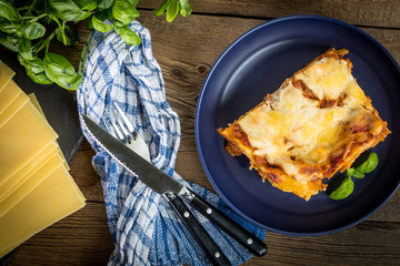 Piece of tasty hot lasagna with red wine.