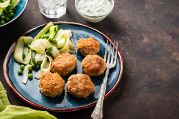 Chicken meat balls with zucchini salad and green peas, with garlic-yogurt sauce.