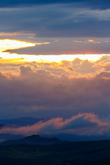 Sunset with colorful clouds in a mountainous landscape