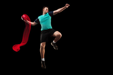 The fit caucasian young male handball player at studio on black background. Fit athlete isolated on black with led light trail . The man in action, motion, movement. attack and defense concept