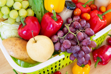 Fresh fruits and vegetables in green shopping basket