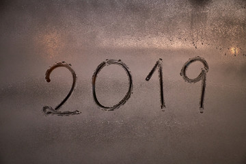 written the number of the new year 2019 on a window with a foam spray