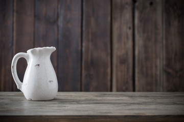 white jug on wooden background