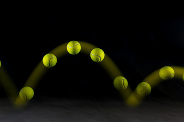 Movement or bounce of tennis ball isolated on black background. - Powered by Adobe