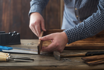 carpenter working with tools on wooden background