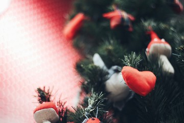 Heart shape Christmas Ornament on new year pine tree with red background for text