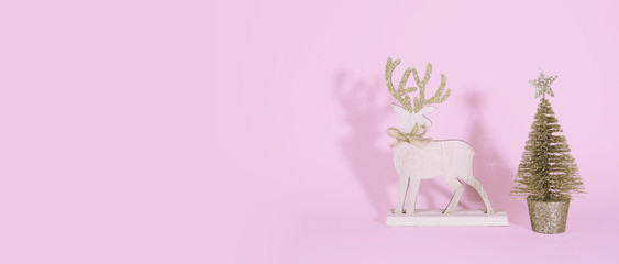 Christmas wooden tree with reindeer over pink background.
