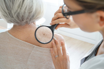  Senior woman getting skin checked by dermatologist - 238404798