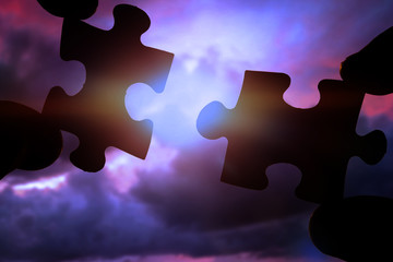 puzzles in the hands of people on the background of the evening sky. logic, logical thinking. interaction.