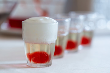 Row of alcohol shots with creamy foam