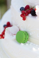 Colorful green macaroon on an iced wedding cake