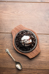 sizzling chocolate brownie is a sweet dish made using scoop of ice-cream on top served with a...
