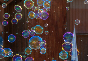 Many soap bubbles in air on city street, outdoor fun for everybody