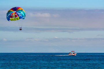 Sea and beach sport for tourists, parasailing in blue sky