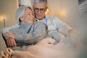  Lovely looking senior couple relaxing together on couch at home