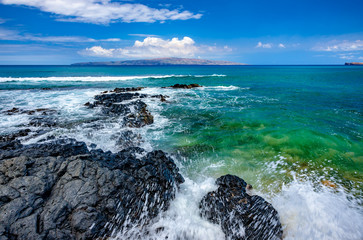 rocky shore with island and clouds