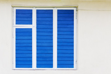 Fototapeta premium The old window is painted blue. The wire is on the wall.