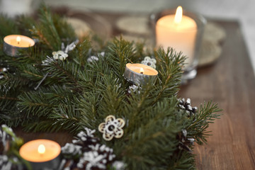 Obraz na płótnie Canvas Christmas, Advent Decorative Wreath Candle Decoration. In a burning candle in a beautiful decorative wreath.