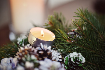 Advent decoration, wreath, candle. In the dark a candle in a beautiful decorative wreath is burning.