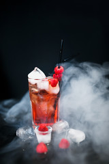 Raspberry ice cold refreshing cocktail with berries. Flat lay, Front view. Smoke envelops