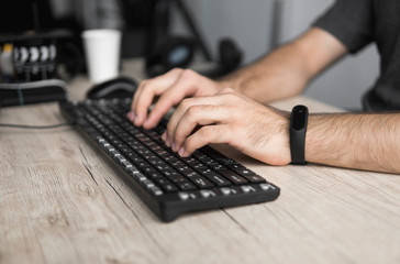 Close up portrait of male hands typing on computer keyboard.