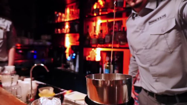 Man makes an alcoholic cocktail, he mixes ingredients in shaker.
