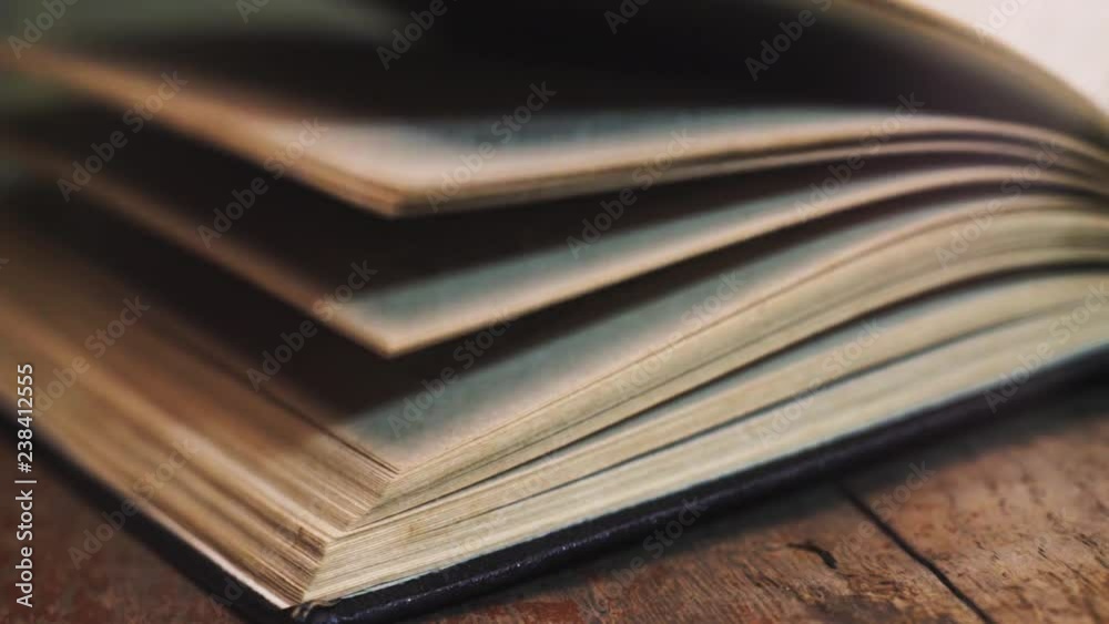 Poster old book pages macro view on a old wooden table. beautiful dark background.