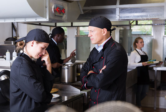 Exasperated chef scolding female employee