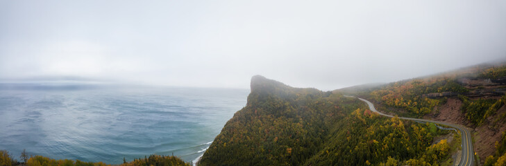 Obraz premium Aerial panoramic view of a Scenic Highway on the Atlantic Ocean Coast during a cloudy day. Taken in near Percé, Quebec, Canada.
