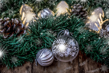 Fototapeta na wymiar Christmas decoration on garland glass balls, twinkle light, pine cones with bokeh at the background