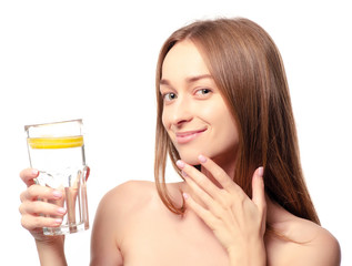 Fototapeta premium Beautiful woman a glass of water with lemon in hand health beauty on white background isolation