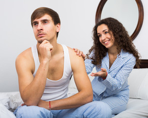 Smiling girl trying to comfort upset husband