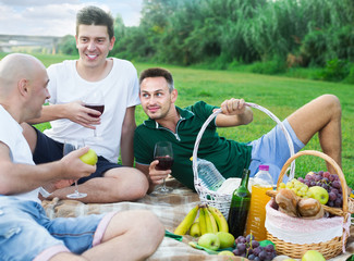 Three friends enjoying life on picnic outdoors