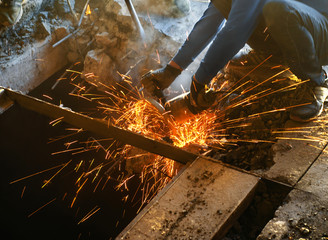 Cutting metal reinforcement in reinforced concrete. Sparks from friction with metal. Disassembly...