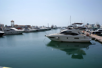 Yachts, boats at the pier in the seaport.