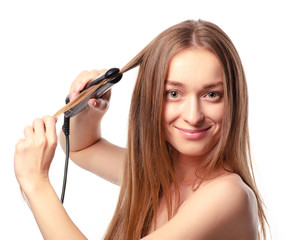 Beautiful woman with a flat iron for hair. Beauty fashion on a white background. Isolation